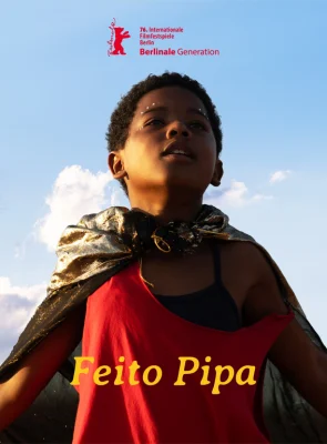 Menino com braços abertos e vestido uma capa.