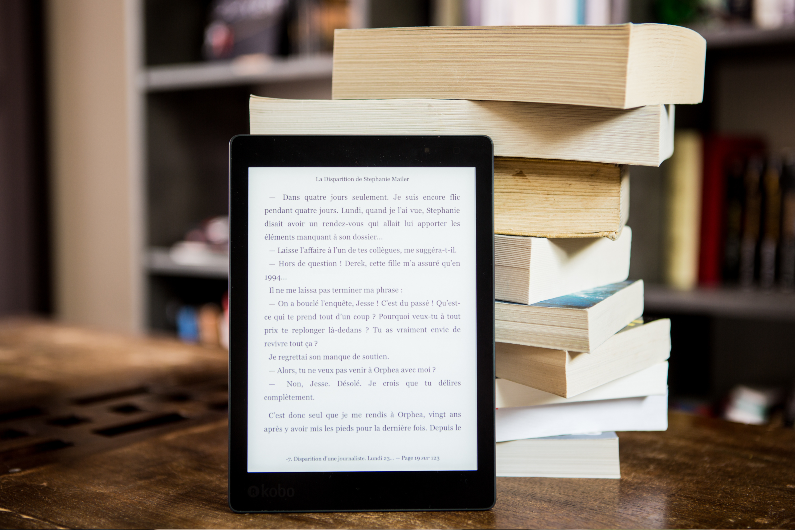 Página de livro aberta em um tablet apoiado em livros