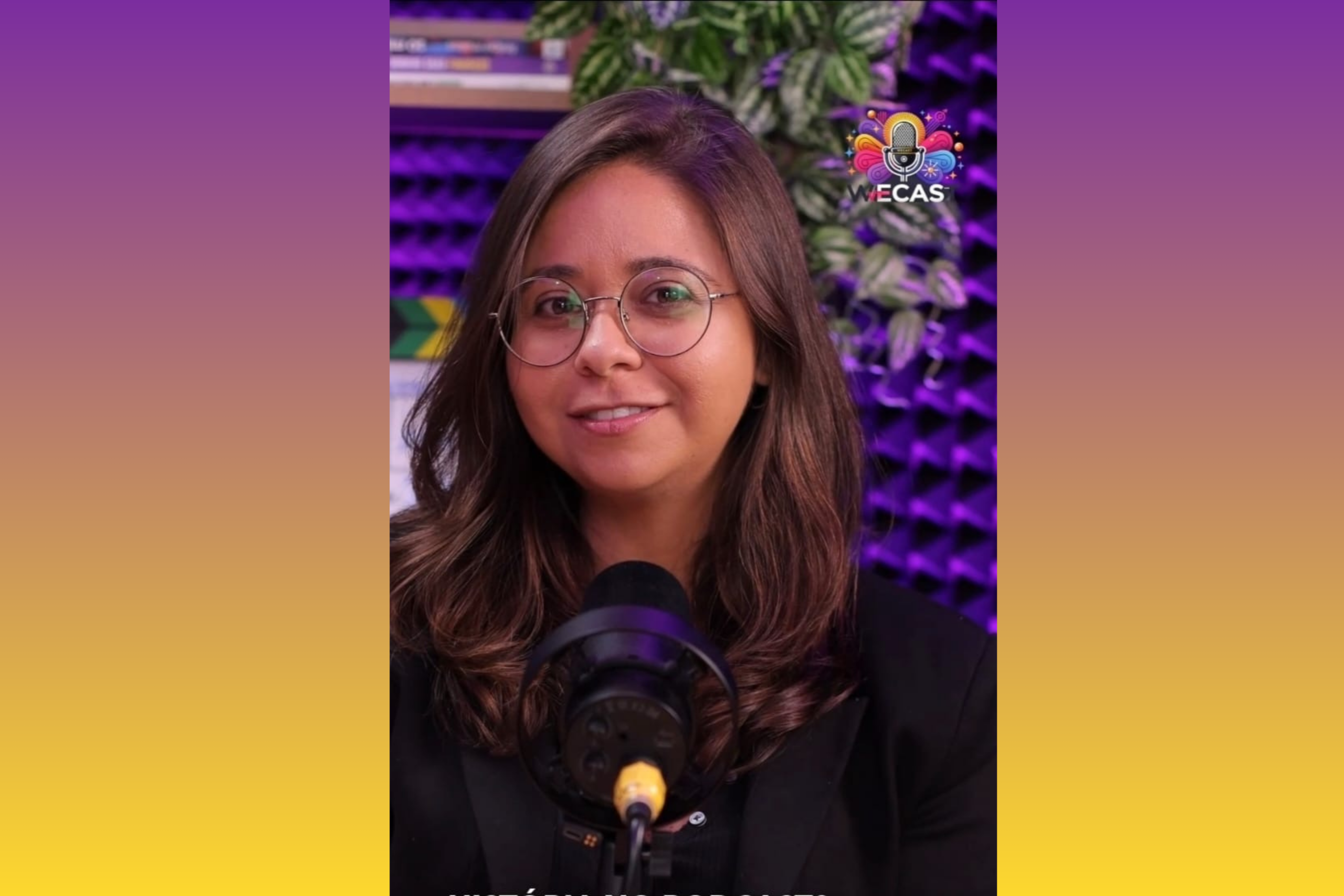 Suellen Mattos está em seu estúdio colorido, com um microfone à sua frente para a gravação de mais um podcast.
