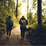 Duas pessoas caminhando por uma trilha usando mochilas.