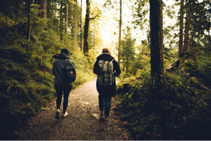 Duas pessoas caminhando por uma trilha usando mochilas.