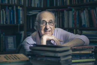 Zuenir Ventura em um biblioteca cheias de livros